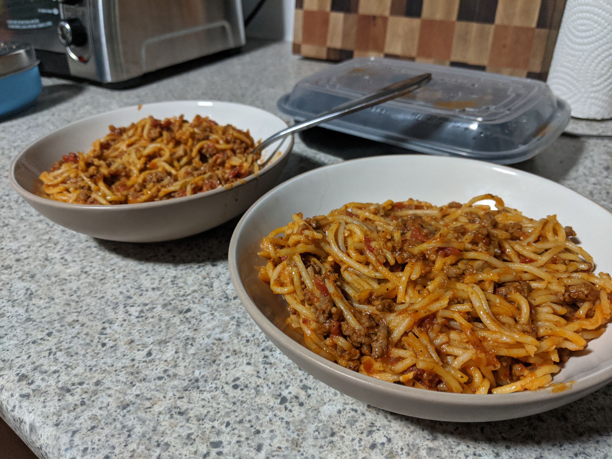 Two bowls sitting on a counter, both filled with spagetti and meat sauce!