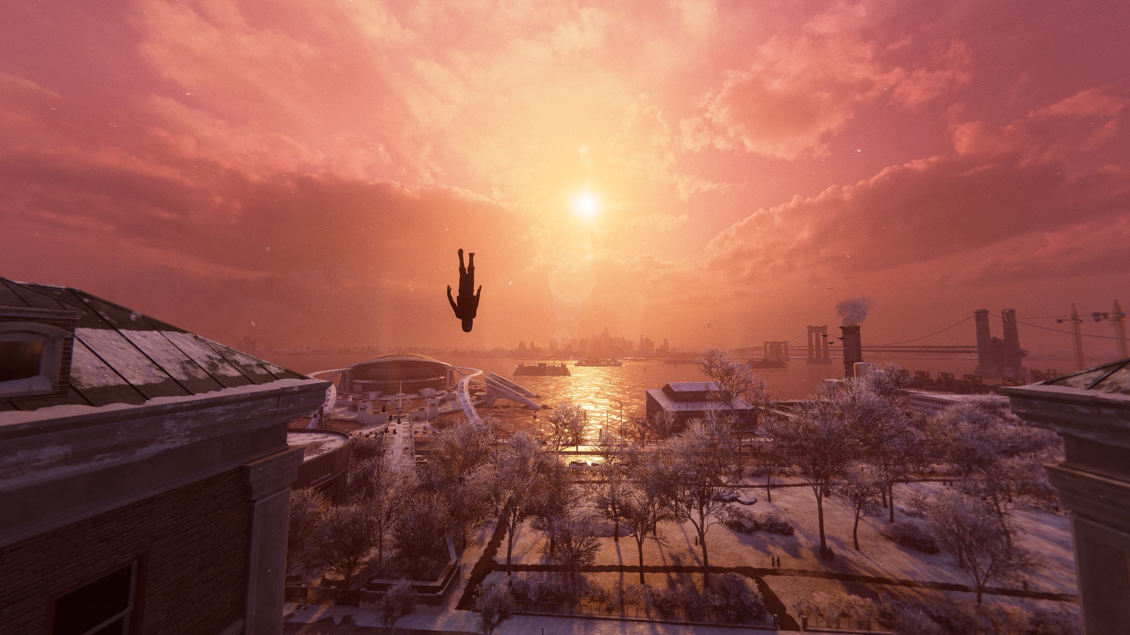 Miles falling in front of a sunset over the city. He is fully upside down.